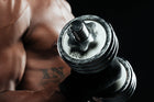 Close-up of a muscular arm holding a dumbbell during a workout, showcasing strength training sessions for bicep development.