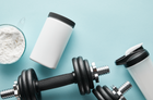 A fitness setup featuring a white container of protein powder, a bowl of white powder with a scoop, a black weight dumbbell, and a shaker bottle on a light blue background, emphasizing essential amino acids for muscle growth and recovery.