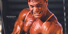 Bodybuilder showcasing an intense workout with visible muscle definition in the chest and arms, emphasizing strength and determination.