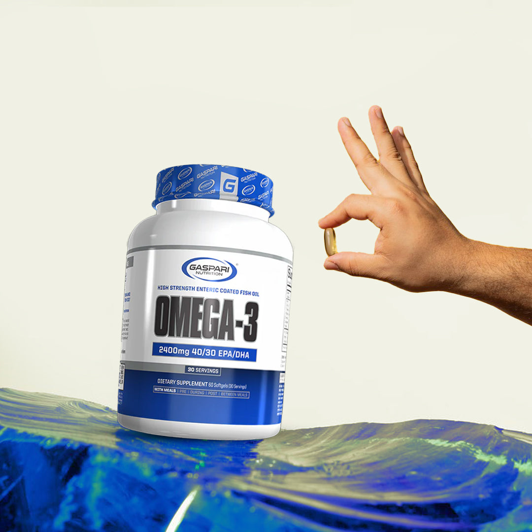 Close-up of a hand holding a Gaspari Omega-3 softgel capsule near the product bottle, emphasizing ease of consumption and dietary supplementation.